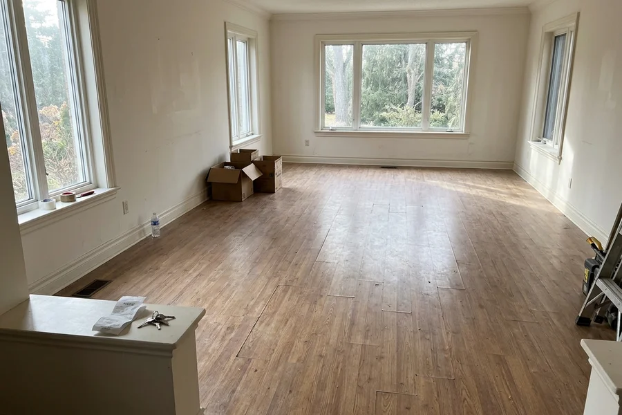 Before walnut hardwood installation: builder-grade floor in a Lorne Park estate living room