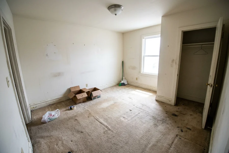 Before laminate flooring installation: worn carpet in a rental bedroom