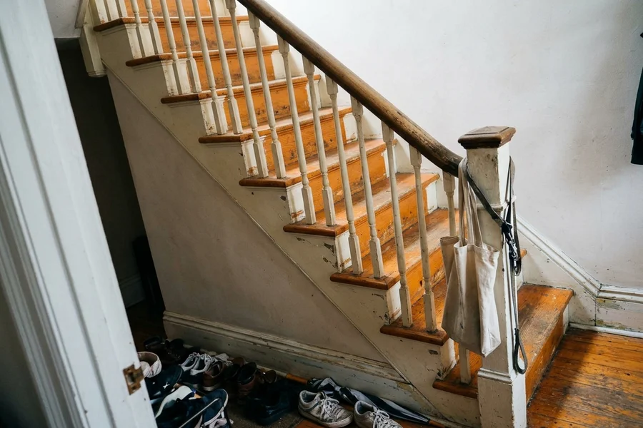 Before hardwood refinishing Toronto: two-tone white risers, stained treads in Riverdale